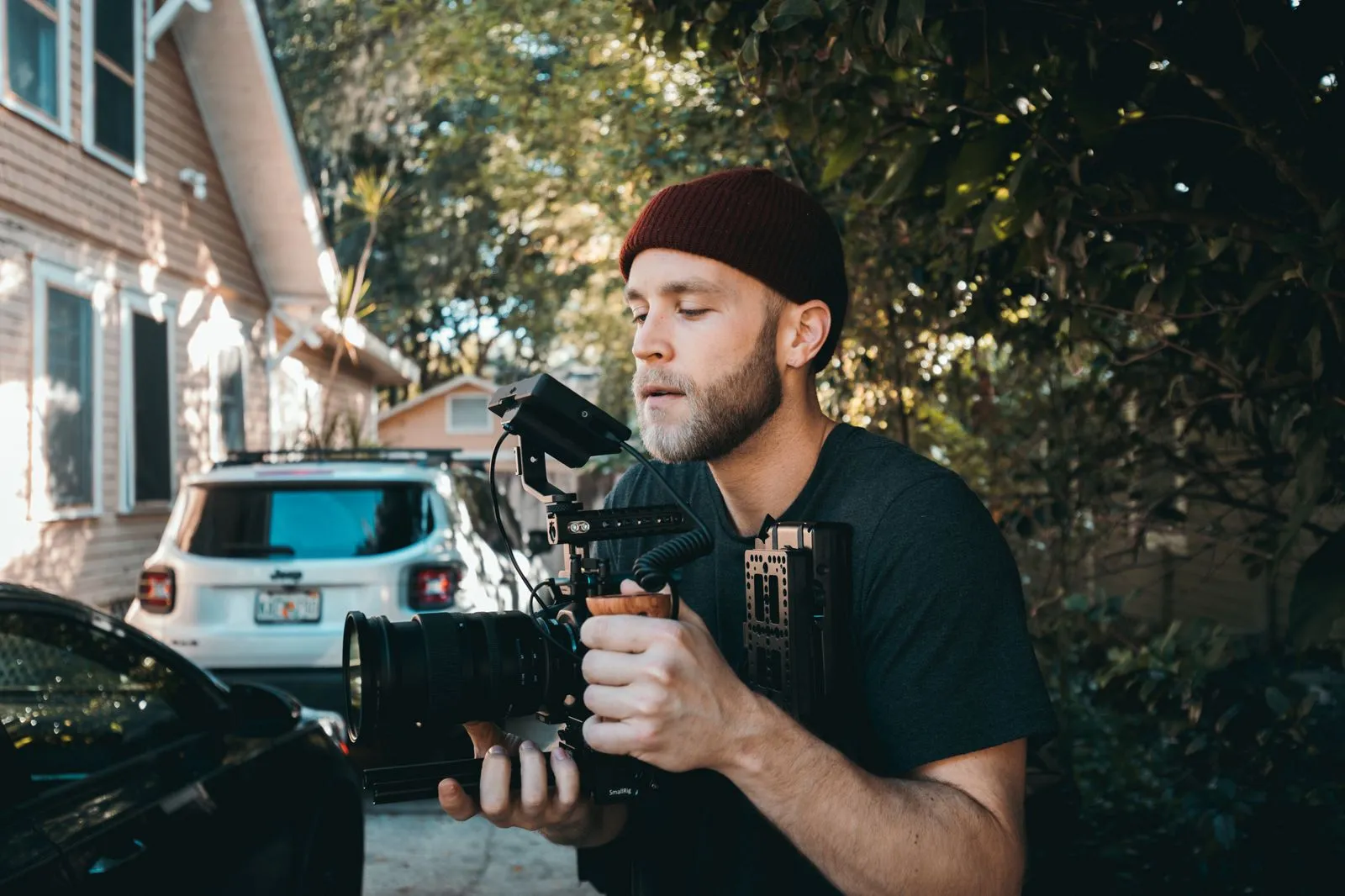 Videographer with camera gear filming outdoors, capturing a creative scene.